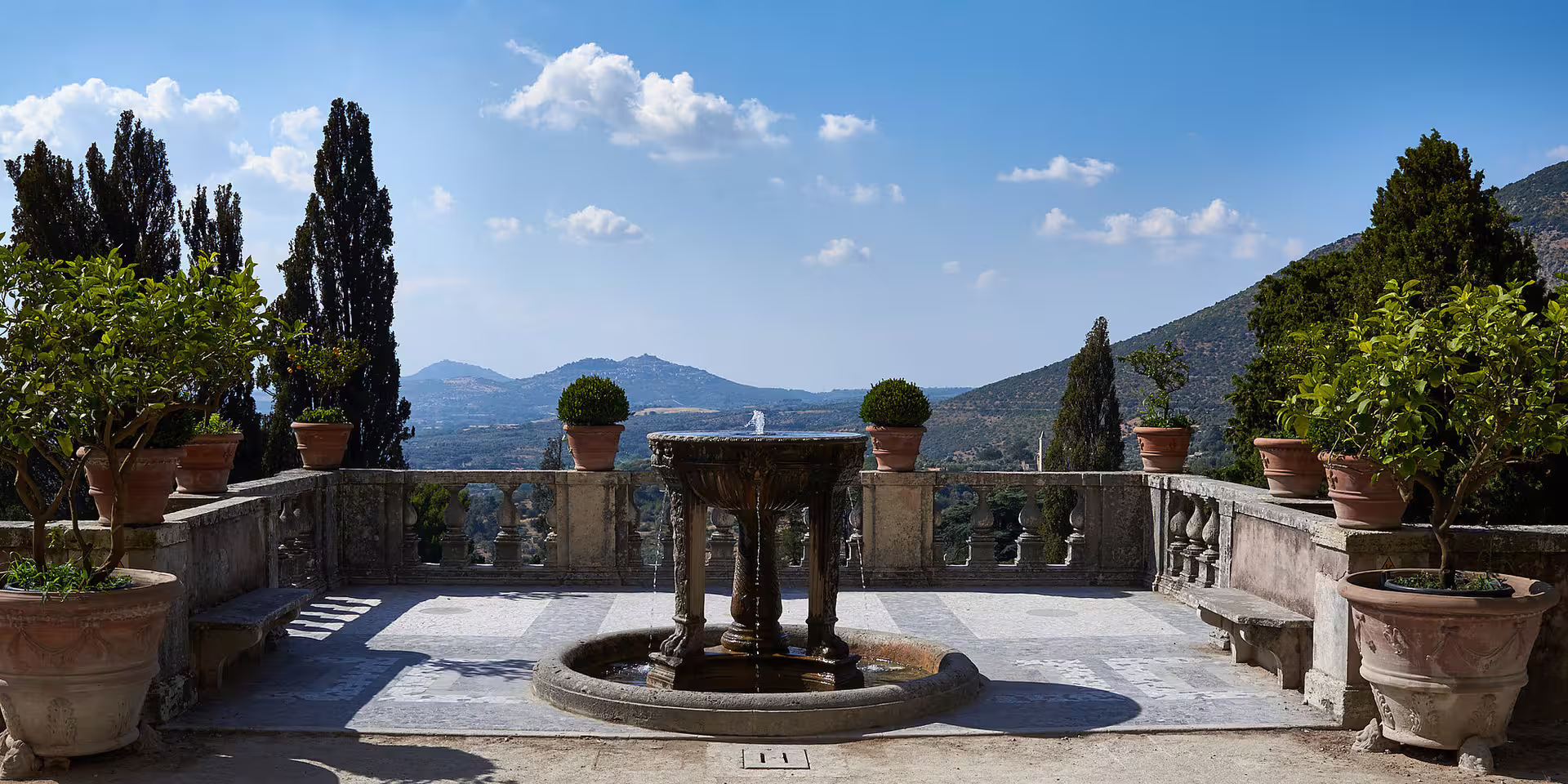 Panoramic terrace of Villa d'Este with fountain, potted lemon trees and hill views on a guided small-group Tivoli tour from Rome