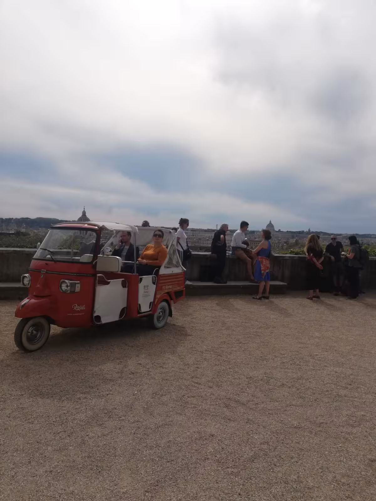 Visitors and a tuk-tuk at a scenic viewpoint during the Villa Medici Combo Tour in Rome.