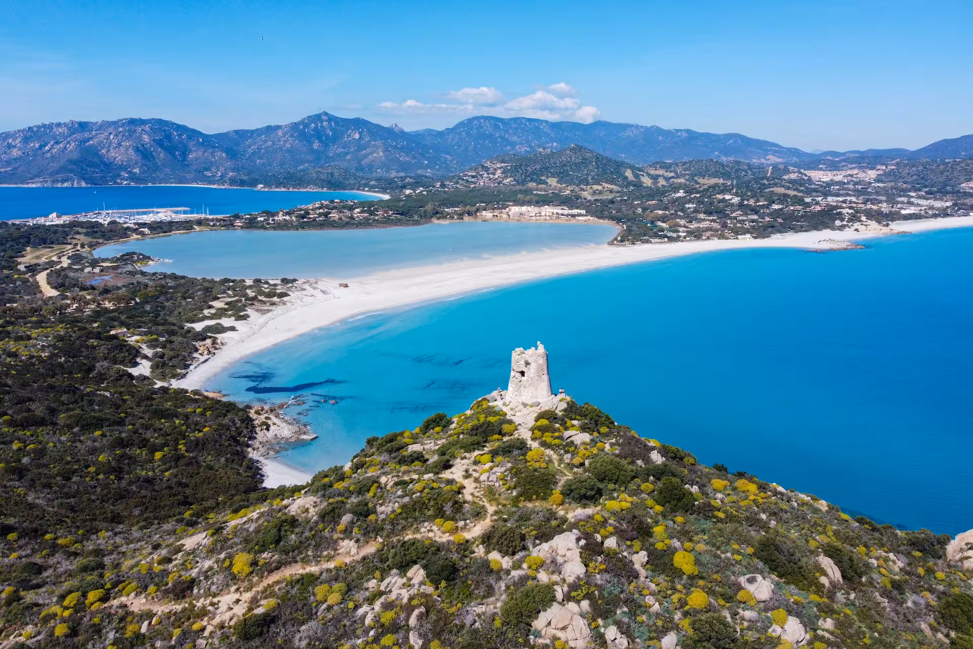 Breathtaking aerial view of Villasimius with turquoise waters, sandy beaches, and lush greenery in Sardinia, Italy.