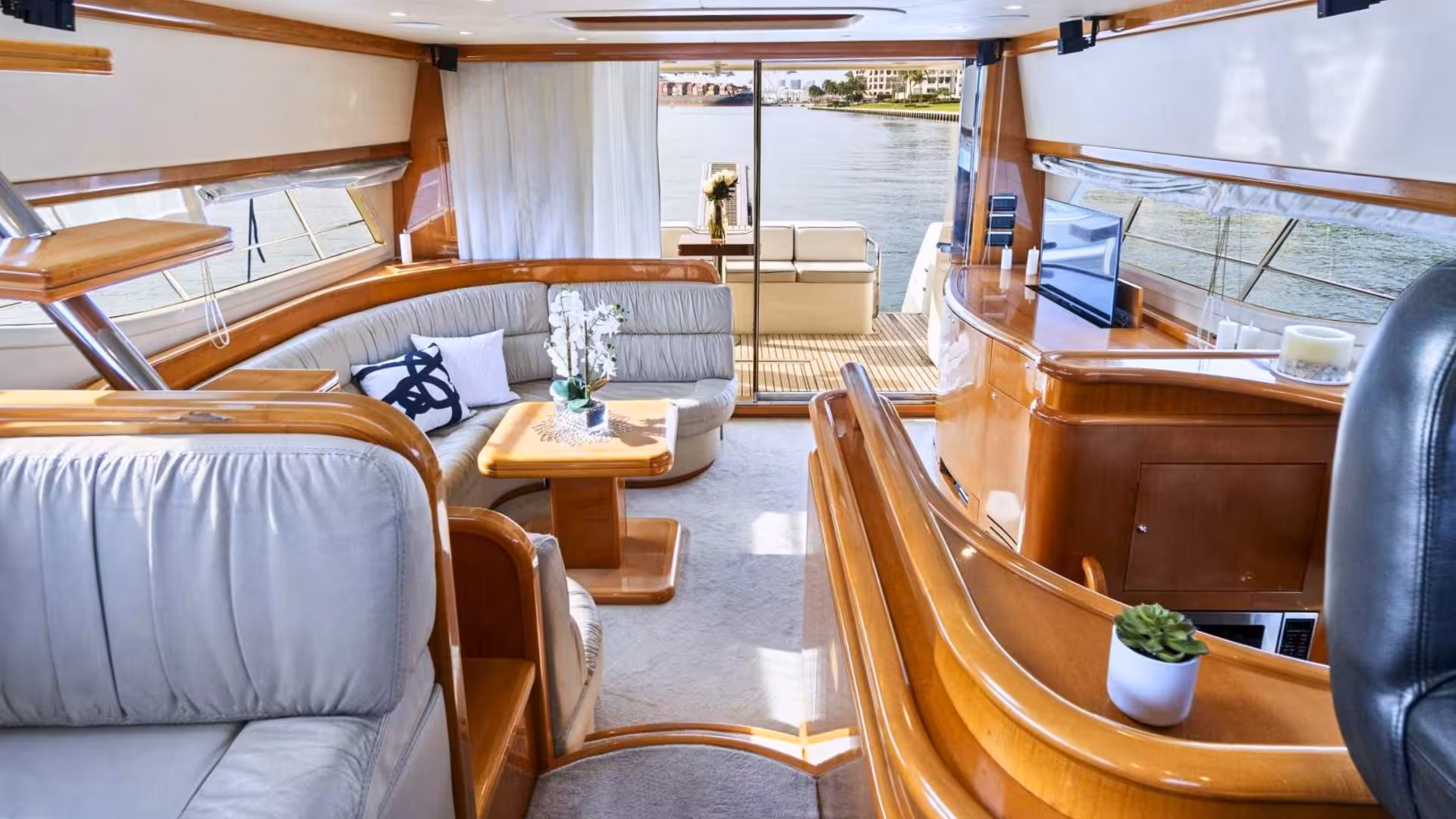 Luxurious yacht interior in Villasimius with plush seating, wooden accents, and panoramic ocean views.