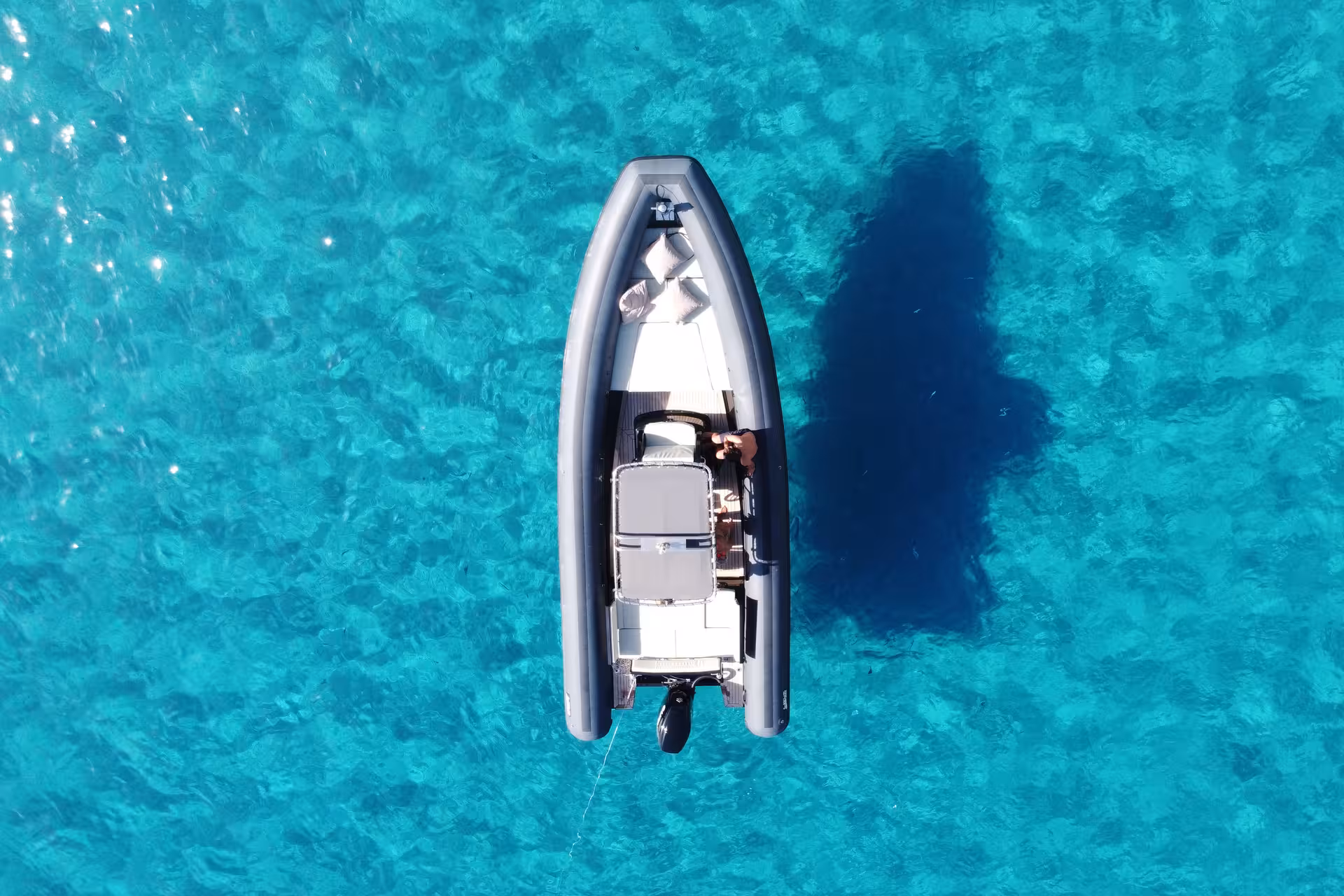 Drone view of a maxi RIB boat floating on crystal-clear waters during a Villasimius snorkeling tour.