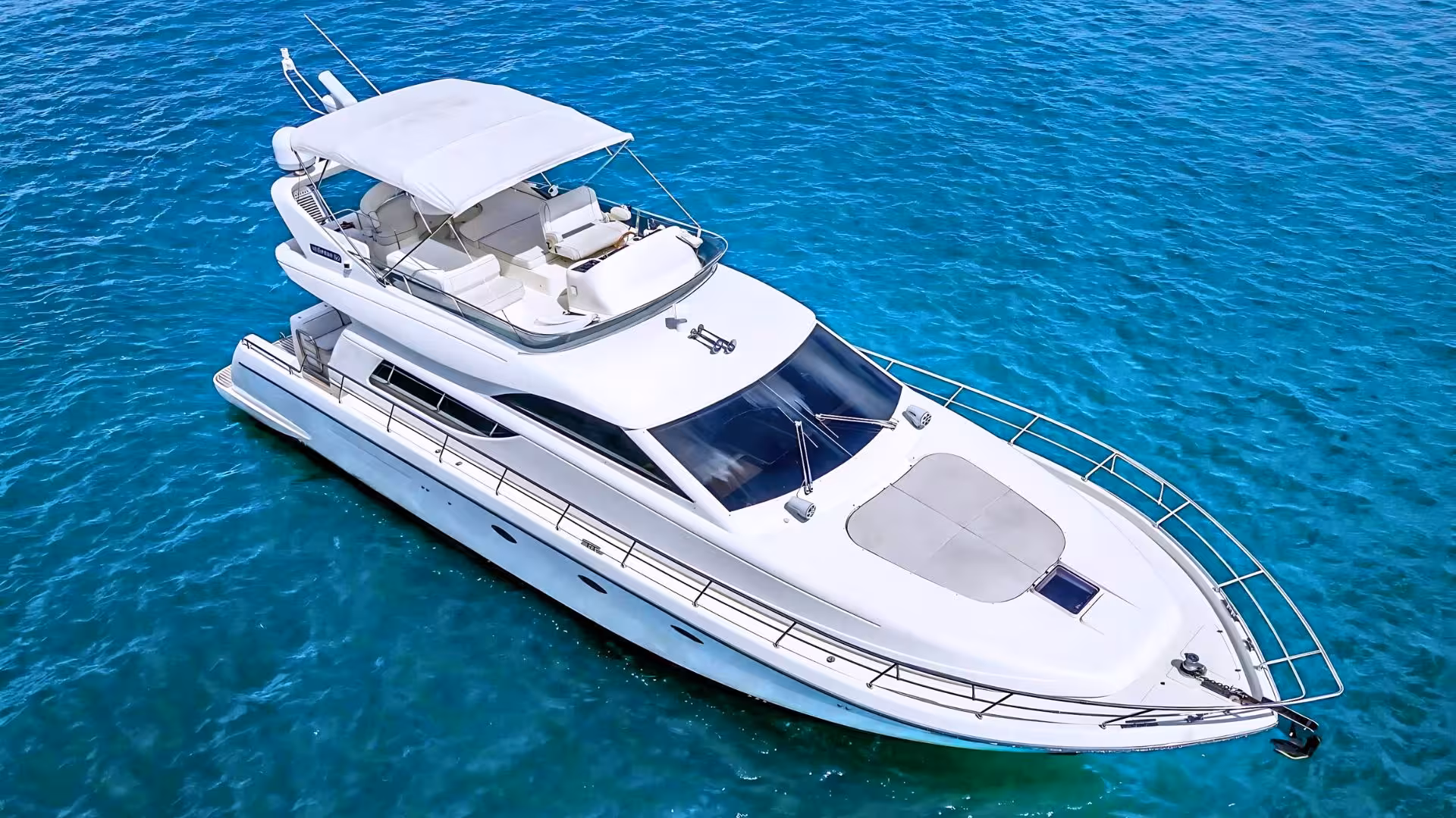 Luxurious white yacht cruising through the clear blue waters of Villasimius on a private tour.