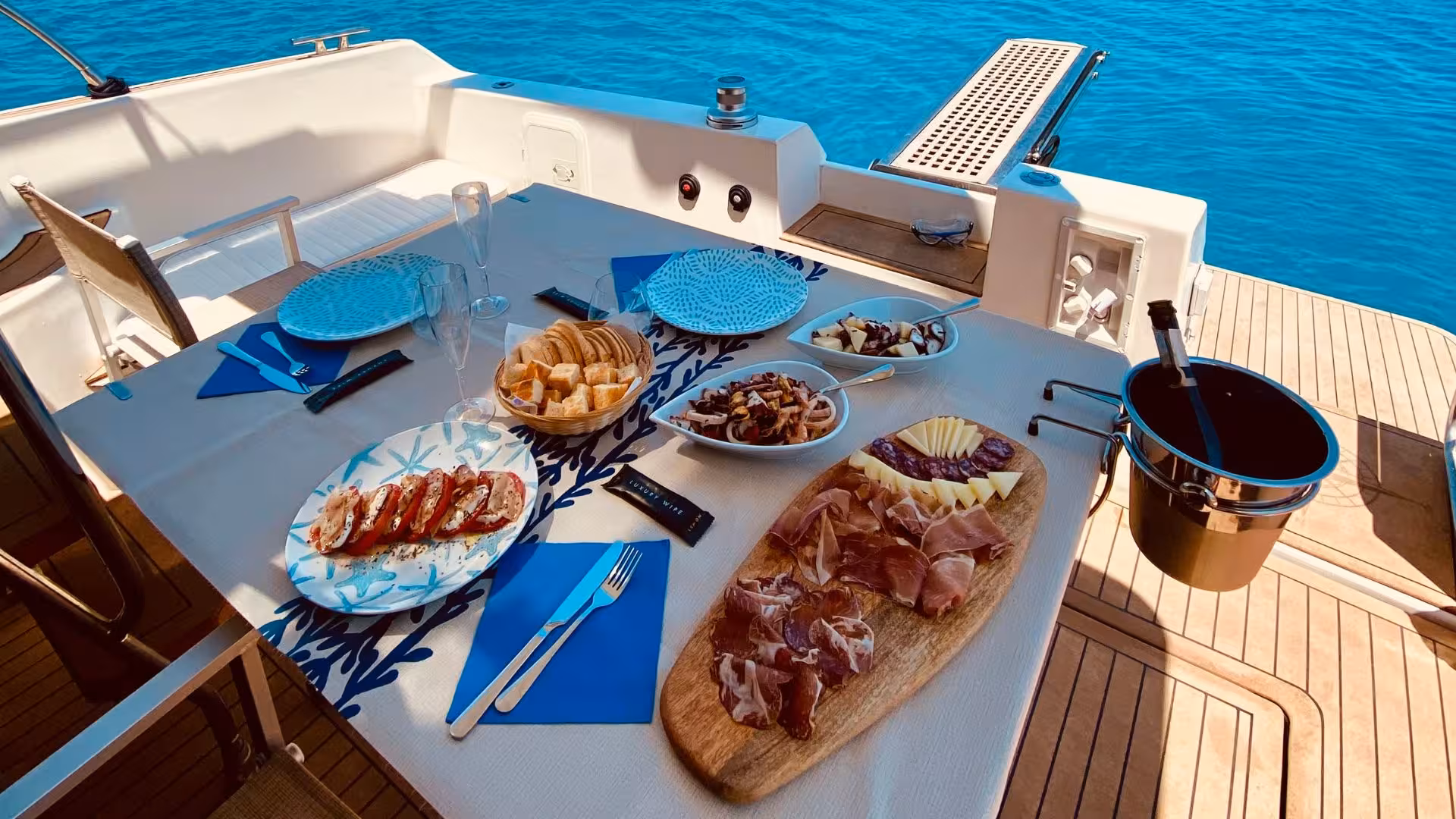 Gourmet Italian antipasto with cured meats and cheese served on a yacht during Villasimius private tour.