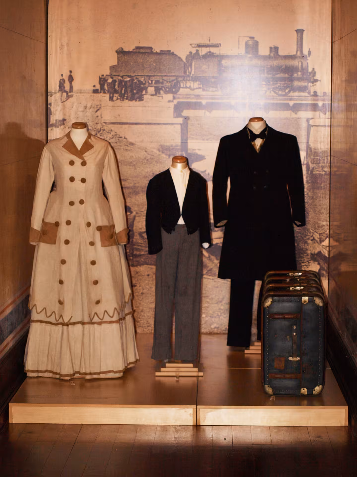 Vintage Algarve railway-era clothing and suitcases displayed in a museum, showcasing regional history and traditions