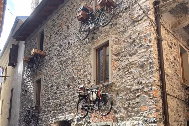 Vintage bicycles mounted on stone wall in Varenna village, a highlight of Como day tour from Milan