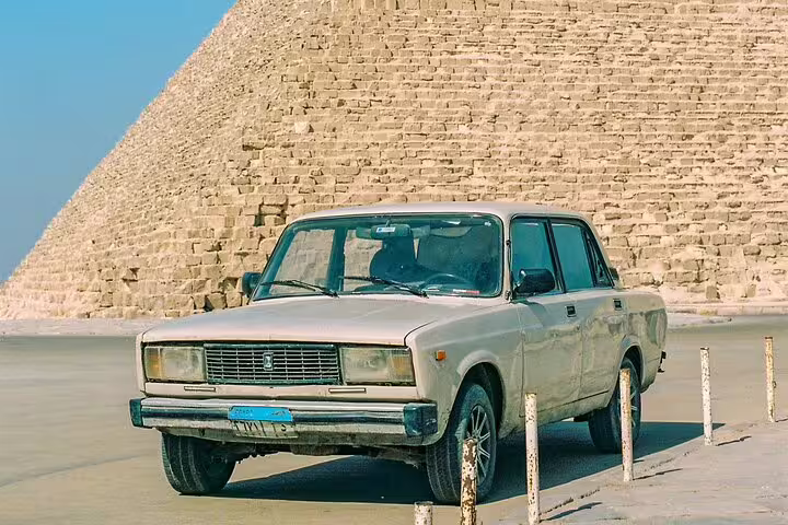 Vintage car parked beside the Giza Pyramid stones, iconic viewpoint on a day tour to Giza Pyramids from Cairo