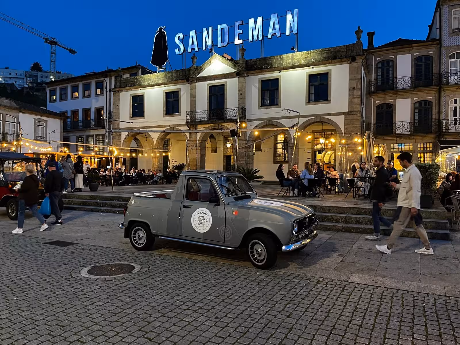 Vintage car parked by Sandeman in Vila Nova de Gaia, Porto by Night Douro River lights and romance tour