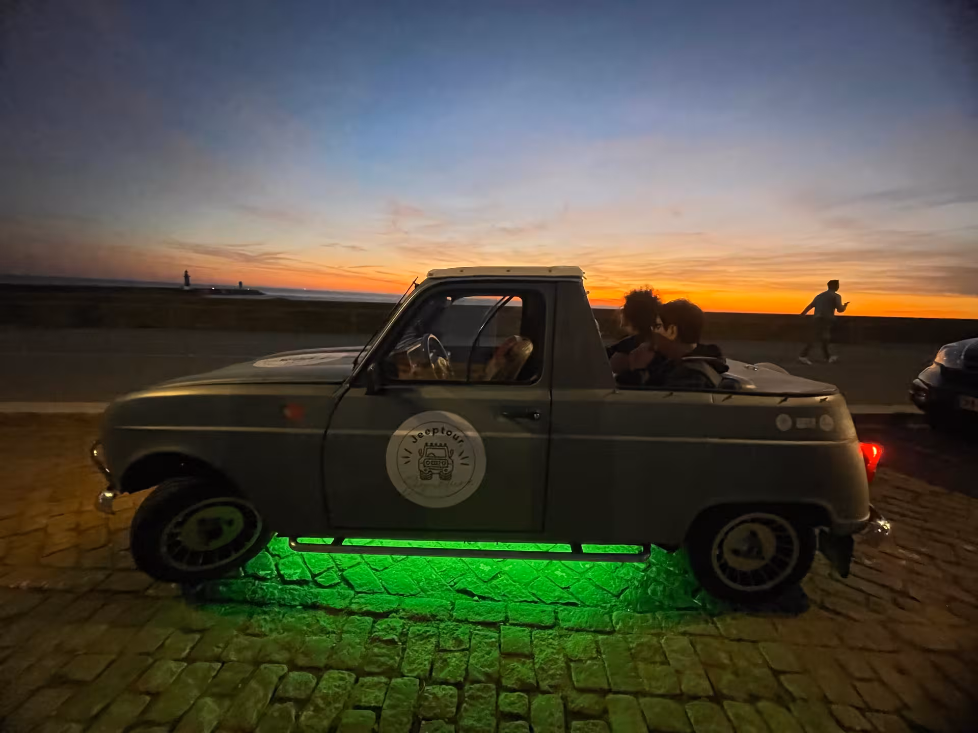 Vintage convertible on Porto waterfront at sunset, glowing lights for Porto by Night romance along the Douro