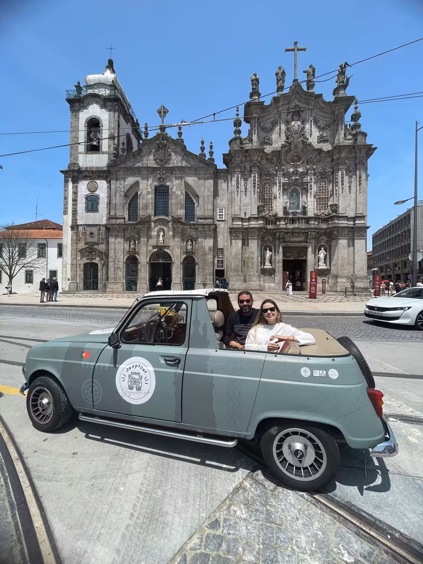 Vintage convertible tour car in front of Porto’s Igreja dos Clérigos, historic sites sightseeing ride