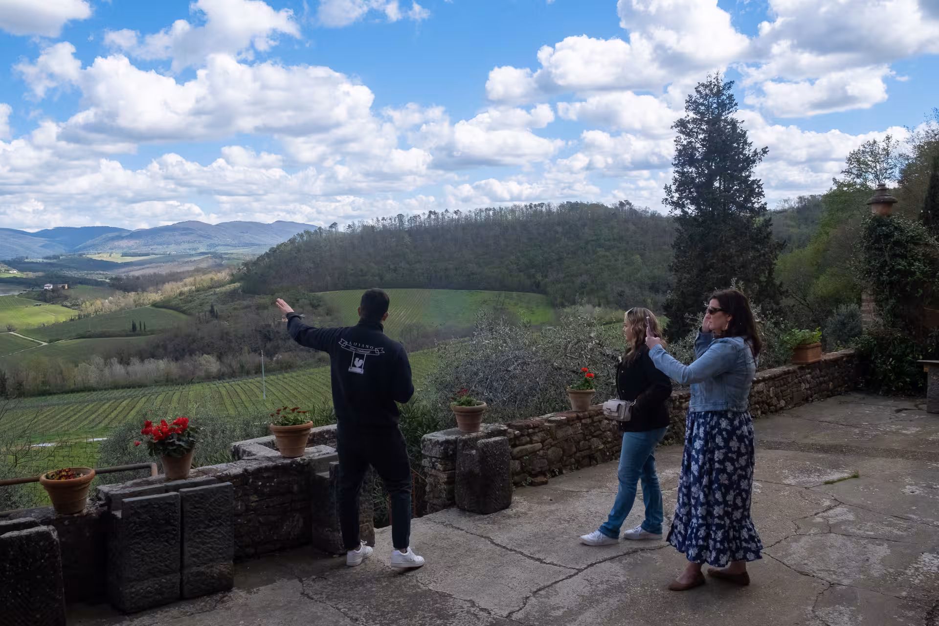 Visitors enjoy panoramic views of Tuscan vineyards during a private olive oil tasting tour.