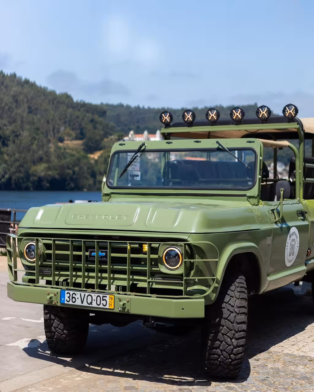 Vintage green 4x4 jeep by the river, North Coast Adventure tour for nature, history and culture sightseeing