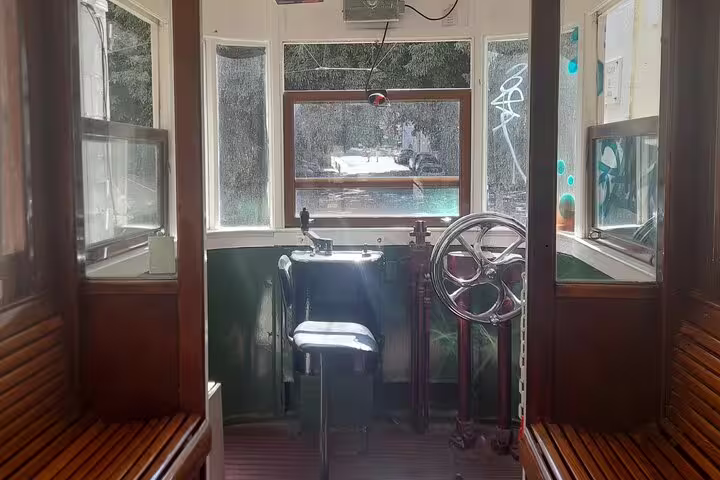 Interior of a vintage tram with wooden benches, highlighting a unique transport experience on the walking tour.