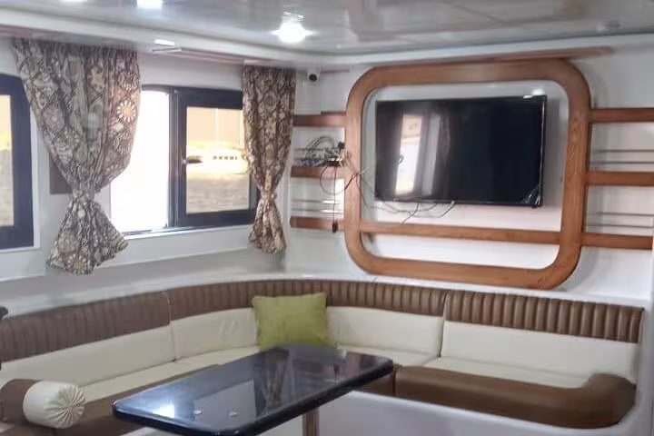 VIP boat lounge seating and TV cabin on Marsa Alam snorkeling trip to Samadai Dolphin House lagoon