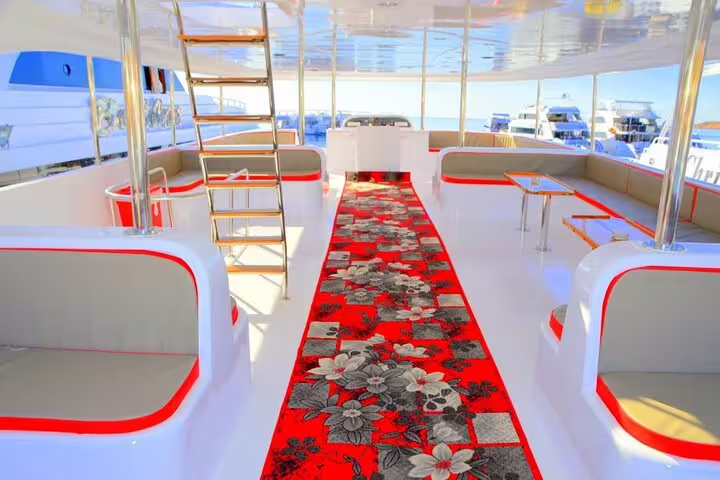 Spacious VIP boat lounge with cushioned seating and red carpet, for White Island and Ras Mohamed snorkeling cruise