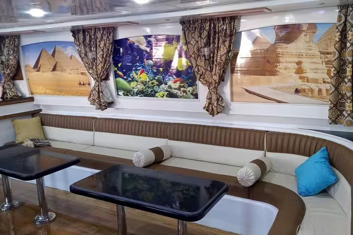 VIP boat salon with tables and comfy seating for Hamata Island snorkeling day trip from Marsa Alam