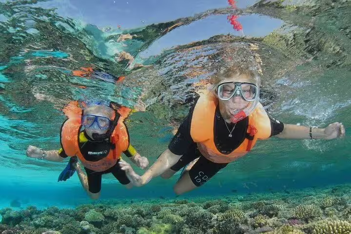 VIP boat snorkeling in Ras Mohamed, Sharm El Sheikh, with swimmers above vibrant Red Sea coral reef