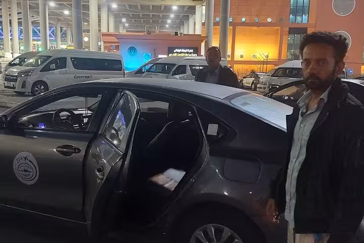 Chauffeur and luxury car at Cairo airport providing VIP meet and assist international transfer service.