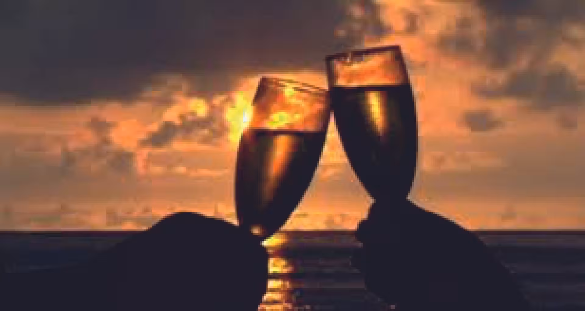 Champagne glasses toasted against ocean sunset, ideal moment on a private VIP catamaran sunset and wine cruise