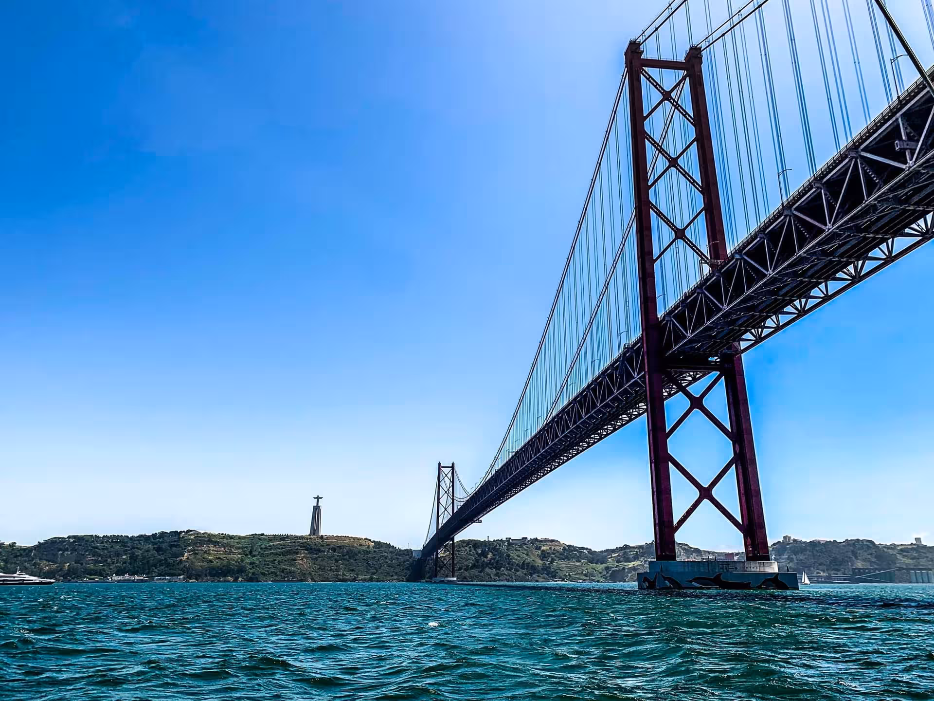 25 de Abril Bridge over the Tagus River seen from a VIP private catamaran tour in Lisbon at sunset