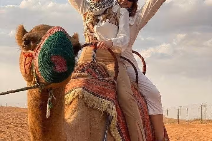 Tourists riding a camel in the Egyptian desert on a VIP Giza Pyramids and Sakkara all-inclusive tour