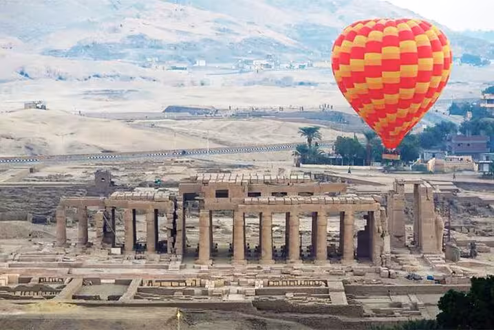 VIP hot air balloon flight above Luxor West Bank temple ruins, including hotel pickup and sunrise views