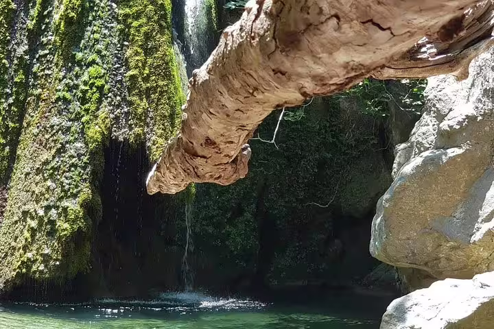 Scenic waterfall surrounded by lush greenery, perfect for a tranquil stop on a VIP luxury 4x4 Land Rover tour.