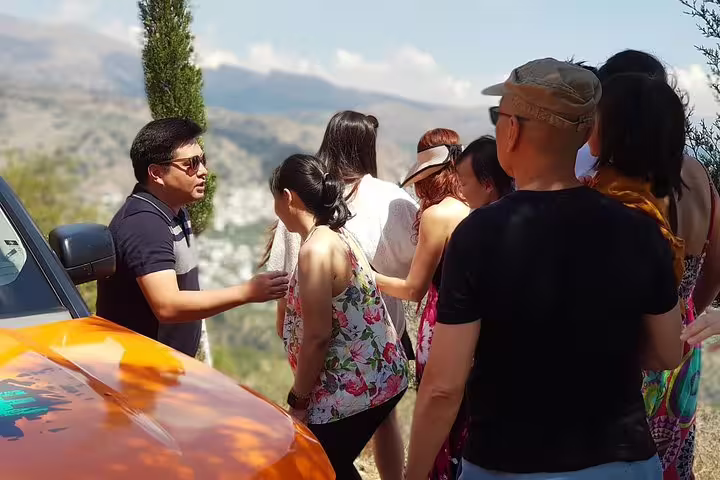 Tour guide engages group with scenic mountain views on a VIP luxury Land Rover 4x4 excursion, highlighting cultural richness.