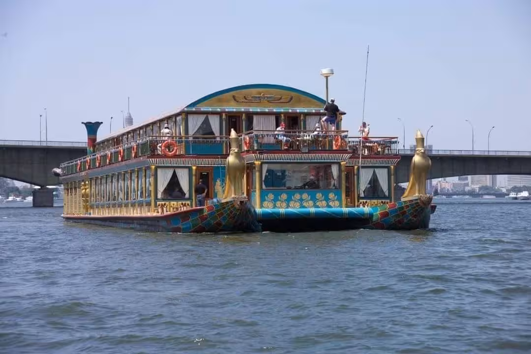 VIP private Nile River dinner cruise boat in Cairo sailing past bridge, elegant Egyptian-style vessel