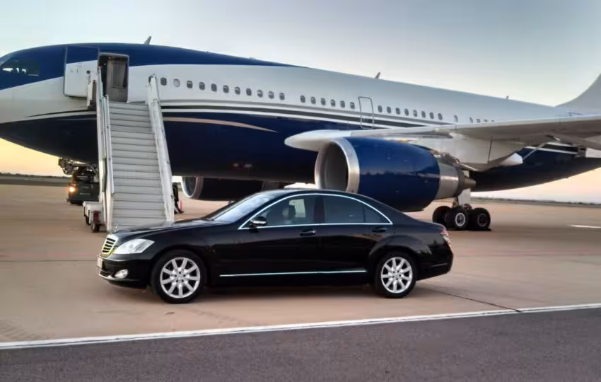 Executive black sedan beside jet for VIP private Cairo airport transfer with meet and greet service