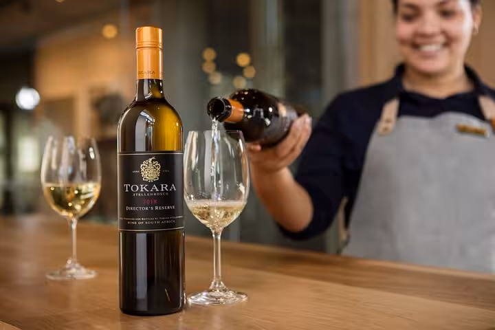 A wine steward pouring Tokara Stellenbosch wine, highlighting premium selections on the Full-Day VIP Stellenbosch Wine Tour.
