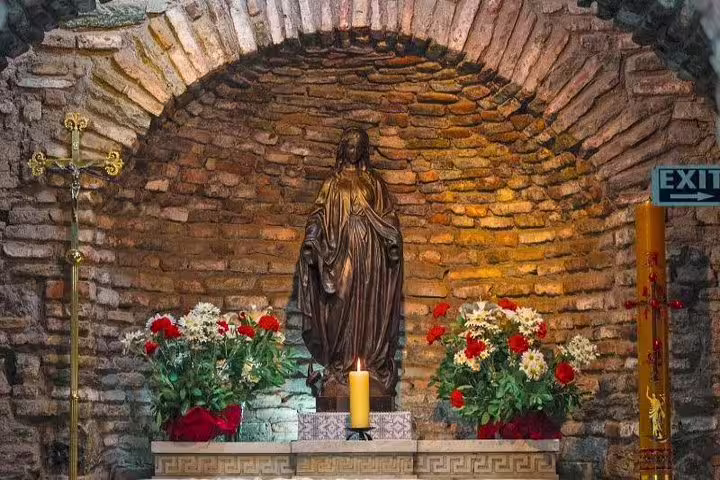 Discover the serene altar with a statue of Virgin Mary adorned with flowers inside the House of the Virgin Mary at Ephesus.