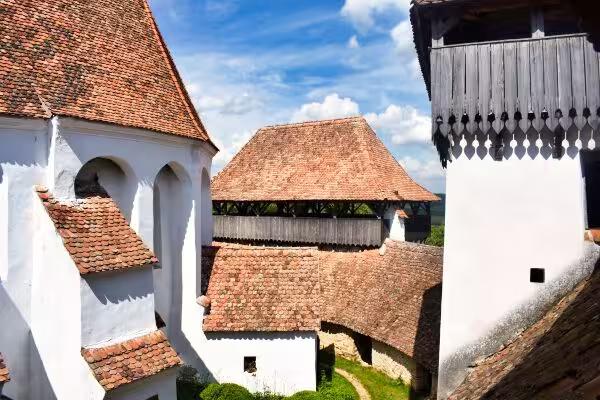 Aerial view of Viscri fortified Saxon church with red-tiled roofs and defensive towers in Transylvania Romania