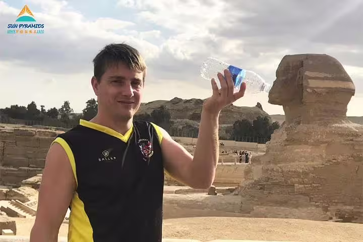 Visitor posing by the Great Sphinx of Giza during a 5 day Cairo vacation package, classic Egypt tour stop