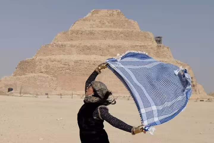 Visitor with scarf in desert before Saqqara Step Pyramid near Giza on a 2-day private Egypt tour