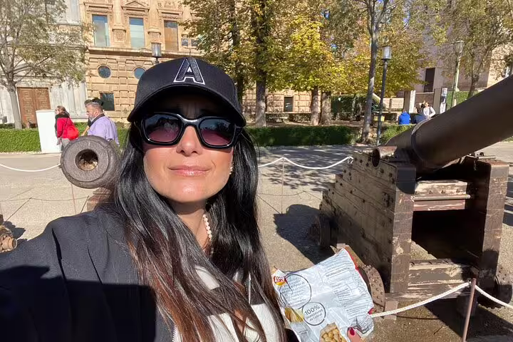 Visitor selfie by Alhambra cannon in Granada, part of a self-guided scavenger hunt and sights tour