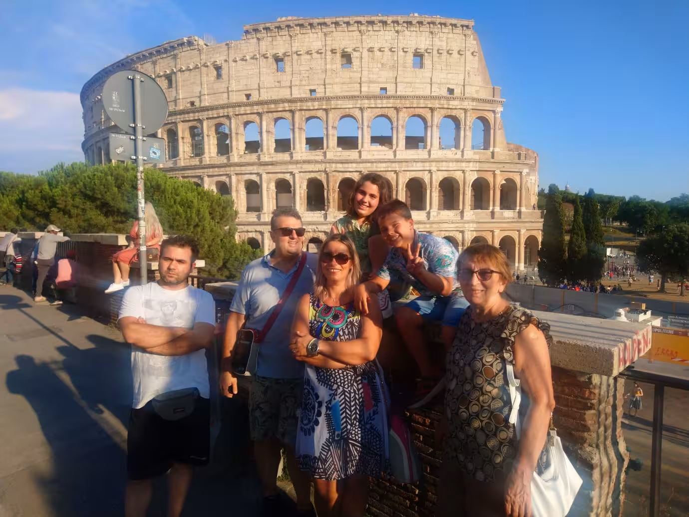 Group of tourists posing in front of the iconic Colosseum in Rome, capturing the essence of historical exploration.