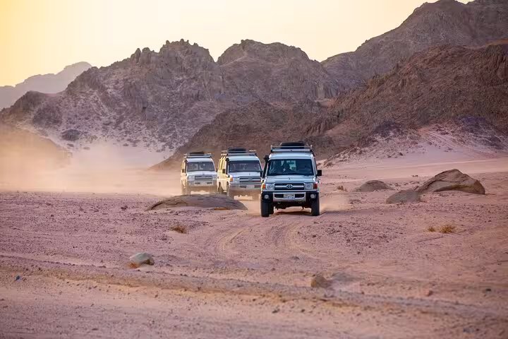 4x4 desert convoy crossing rugged mountains on Viva Safari Quad and Spider Car tour with dinner and show