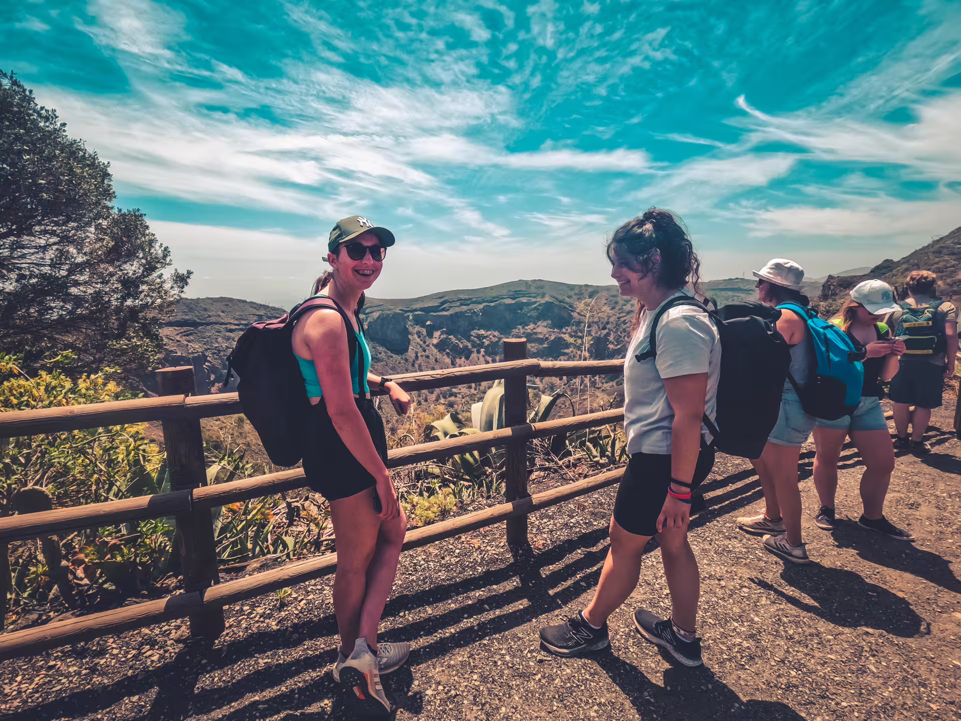Group of tourists enjoying scenic views on the Volcano Heart Tour, surrounded by lush nature and clear blue skies.