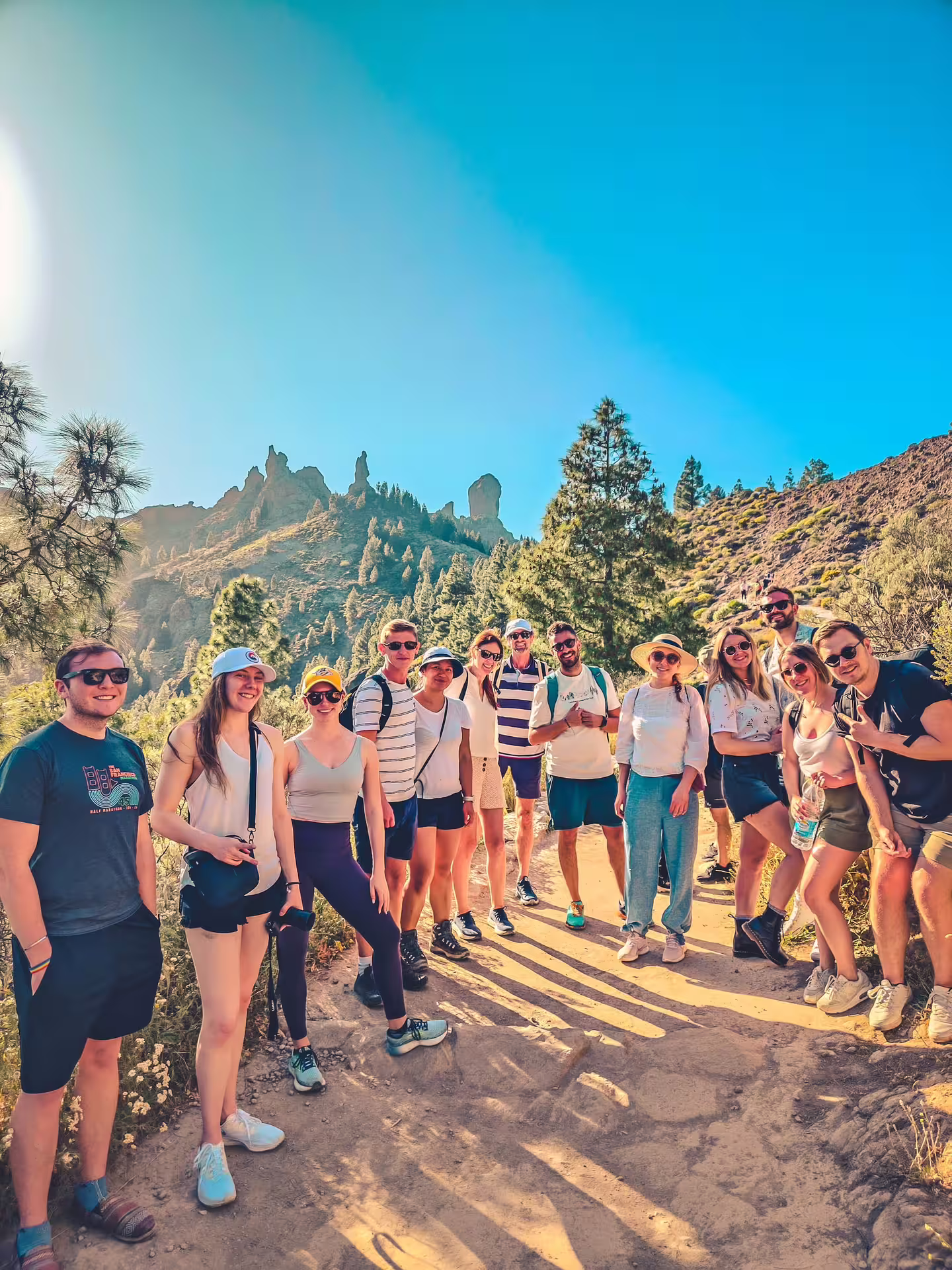 Group of hikers enjoying a sunny trail with volcanic rock formations on the Volcano Heart Tour.