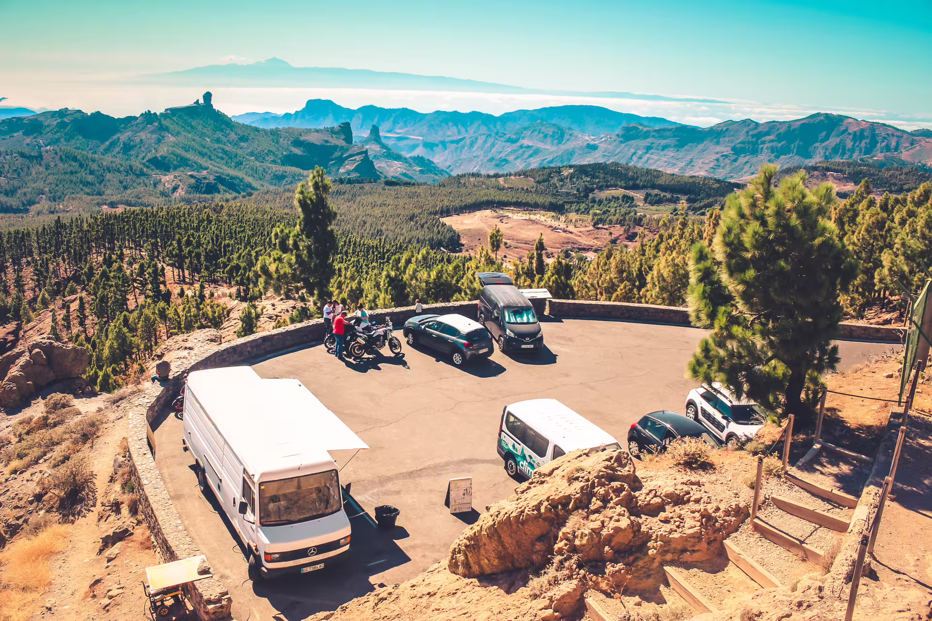 Scenic mountain parking area with vehicles and tours, offering panoramic views on the Volcano Heart Tour.
