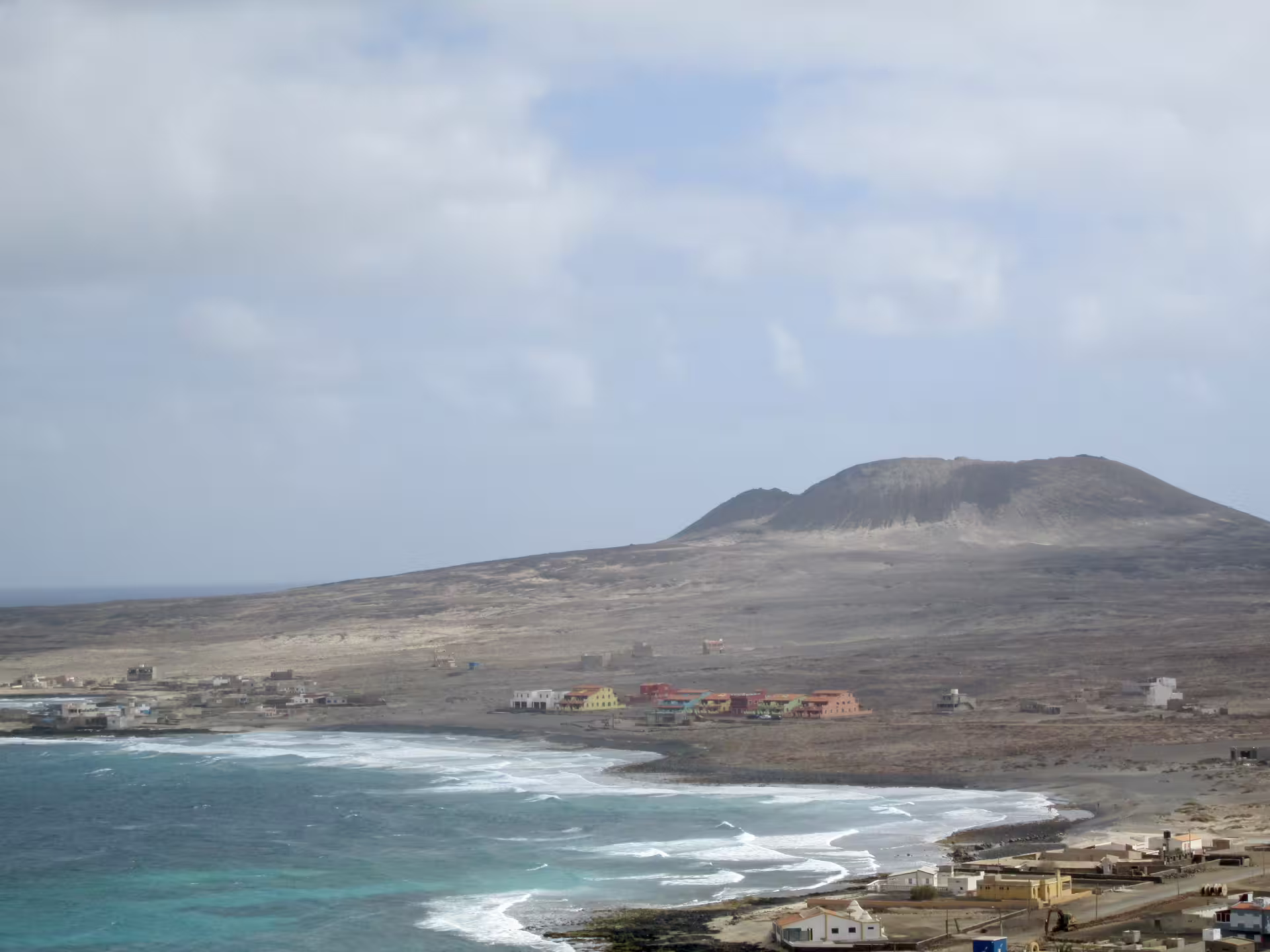 Scenic view of Volcano Viana in São Vicente, Cape Verde, with coastal village and ocean waves, ideal for hiking adventures.