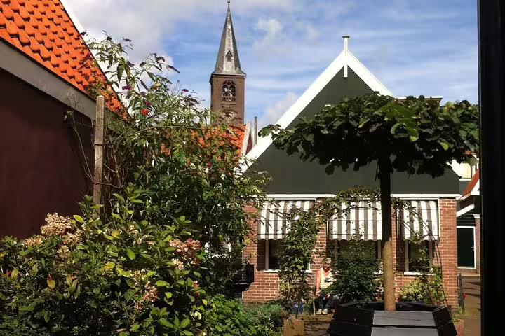 Traditional Volendam houses and church tower, scenic highlight on a half-day private walking tour from Amsterdam