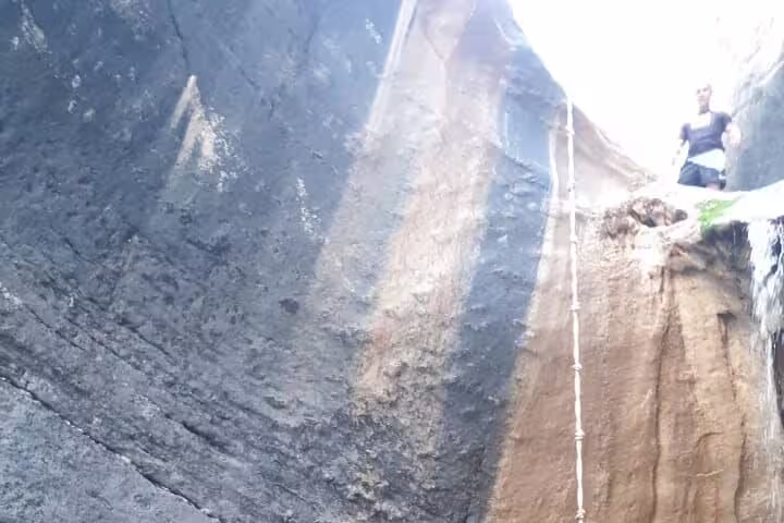Adventurer exploring a deep rock formation in Wadi Dham, showcasing rugged terrain on a private full-day tour.