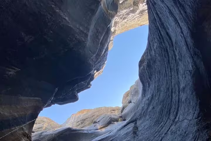 View of the stunning rock formations and clear sky in Wadi Dham, perfect for a full-day adventure tour.