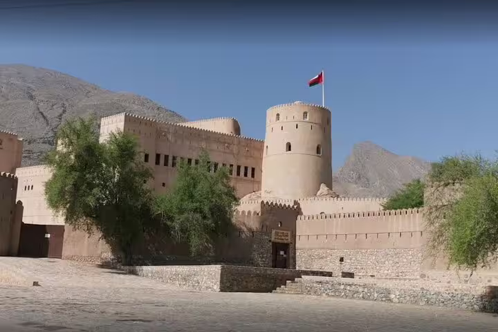 Historic fort with Omani flag in Wakan, showcasing cultural heritage on the 2 Days 1 Night Wakan Private Tour.