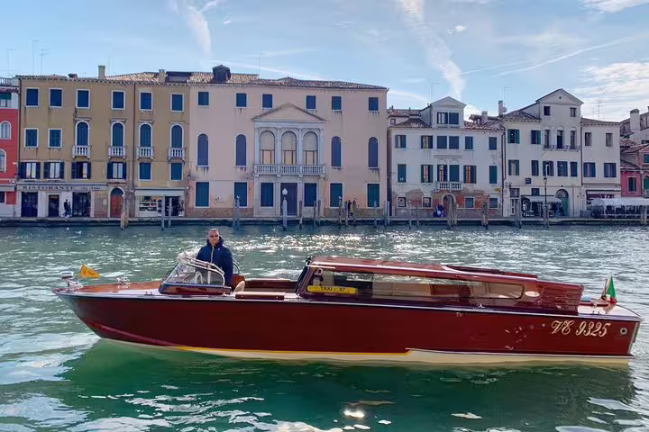 Elegant water taxi cruising through Venice's canals, perfect for Murano and Burano shared tour experiences.