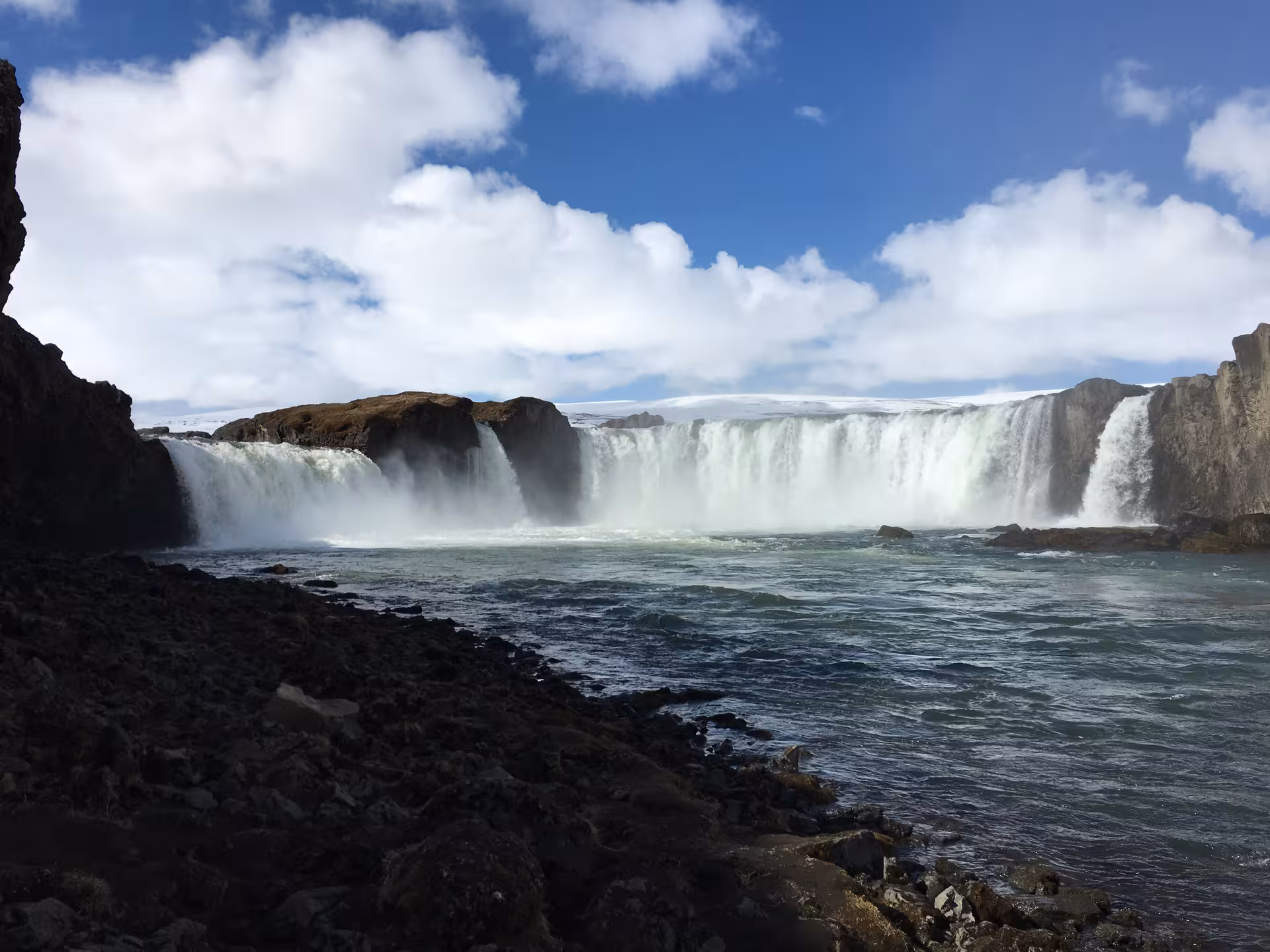 Majestic waterfall cascading into a rocky river, a stunning highlight for a custom photography day tour.