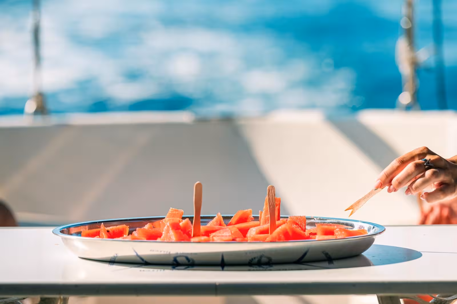 Close-up of a plate with fresh watermelon slices on a sailing trip in Asinara National Park, enjoying the sea breeze.