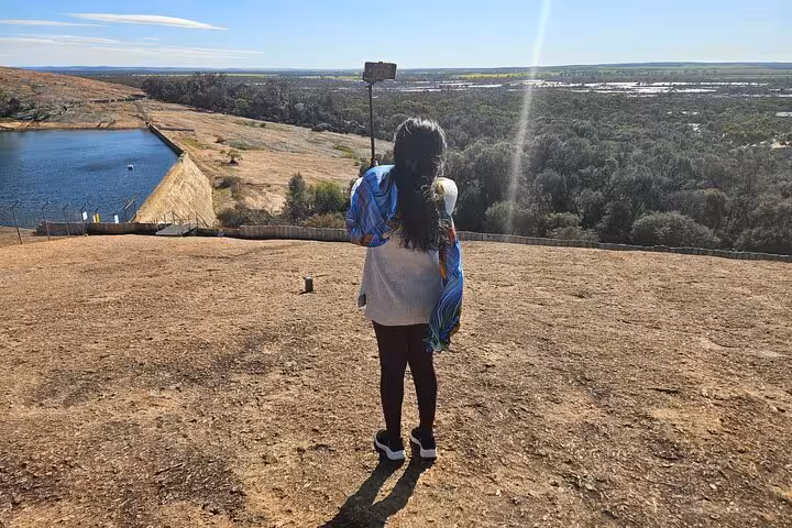 Traveler capturing a scenic view of the vast landscape near Wave Rock on a sunny day tour in Western Australia.