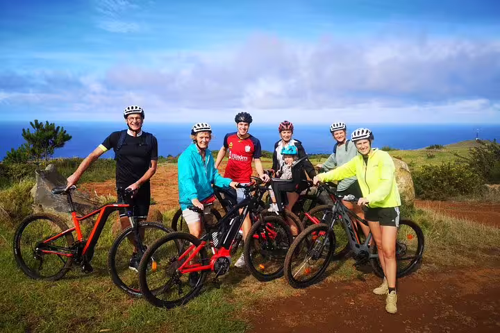 Group of cyclists enjoying a scenic west coast Madeira bike tour with ocean views and lush landscape in the background.